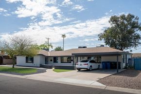Phoenix apartment for rent - A white house with a car parked in front.